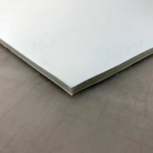 Pode incluir: Close-up de uma placa de espuma branca com uma superf&iacute;cie ligeiramente texturizada.