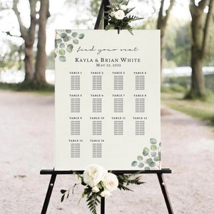 Pode incluir: Um mapa de lugares de casamento com um fundo r&uacute;stico e acentos de vegeta&ccedil;&atilde;o. O gr&aacute;fico lista as mesas de 1 a 14 com os nomes dos convidados. O texto no topo diz "find your seat Kayla & Brian White May 22, 2023".