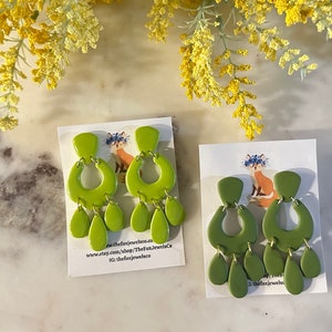 Op de afbeelding: Twee paar groene oorhangers met een druppelvorm. De oorhangers bevinden zich op witte kaartjes met een vos-illustratie en de tekst "thefoxjewels.co" en "www.etsy.com/shop/TheFoxJewelsCo".