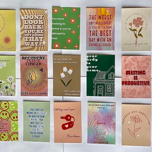 May include: A set of 16 colorful cards with encouraging messages for people in recovery. The cards feature illustrations of flowers, houses, and other designs. The text on the cards includes phrases like "Recovery is not linear", "Resting is productive", and "It's okay to eat".