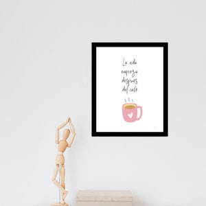 Op de afbeelding: Een zwart ingelijst print met een witte achtergrond en een roze koffiekopje met een hart erop. De tekst op de print luidt "La vida empieza despues del cafe."