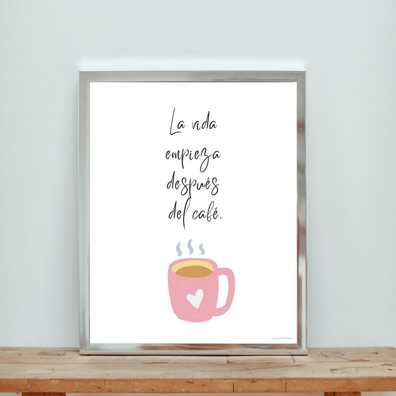 Op de afbeelding: Een wit ingelijst print met een roze koffiekopje en de tekst "La vida empieza despu&eacute;s del caf&eacute;."