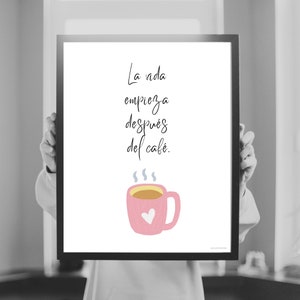 Op de afbeelding: Een witte ingelijste print met een roze koffiekopje en de tekst "La vida empieza despu&eacute;s del caf&eacute;." in zwarte cursieve letters.
