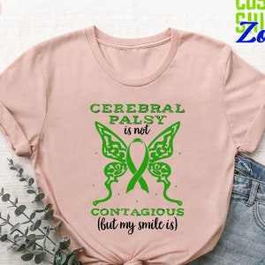 May include: A pink t-shirt with a green butterfly graphic and the text "Cerebral Palsy is not contagious (but my smile is)".