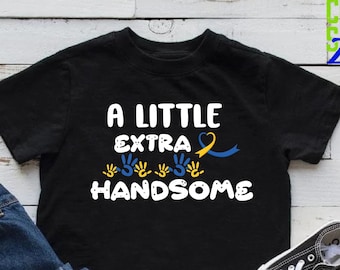 May include: Black t-shirt with the text "A Little Extra Handsome" in white. The text is surrounded by yellow and blue handprints and a yellow and blue ribbon.