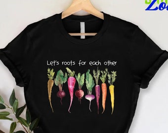 May include: Black t-shirt with a white graphic of colorful vegetables and the text "Let's roots for each other".