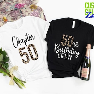 May include: Two t-shirts with a leopard print design. One shirt is white with the text "Chapter 50" and the other shirt is black with the text "50th Birthday Crew".