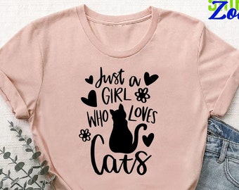May include: A pink t-shirt with the text "Just a girl who loves cats" in black lettering. The text is surrounded by small hearts and flowers.