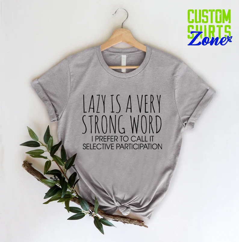 May include: Gray t-shirt with the text "LAZY IS A VERY STRONG WORD I PREFER TO CALL IT SELECTIVE PARTICIPATION" printed on it.
