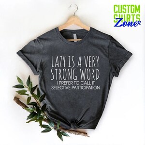 May include: Dark gray t-shirt with white text that reads "LAZY IS A VERY STRONG WORD I PREFER TO CALL IT SELECTIVE PARTICIPATION".
