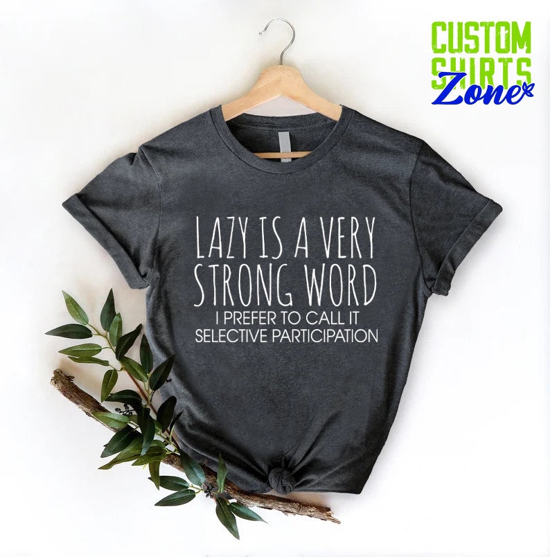May include: Dark gray t-shirt with white text that reads "LAZY IS A VERY STRONG WORD I PREFER TO CALL IT SELECTIVE PARTICIPATION".