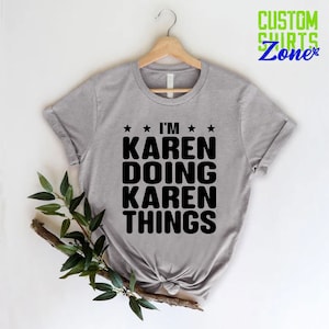 May include: A gray t-shirt with the text "I'm Karen Doing Karen Things" in black lettering. The shirt is on a hanger and has a white background.