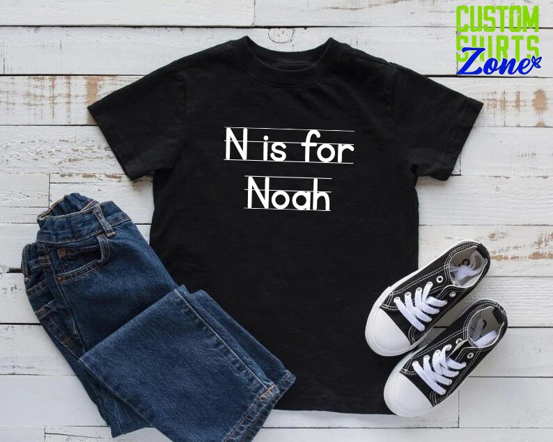 May include: Black t-shirt with white text that says "N is for Noah".