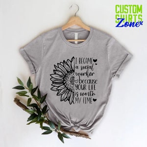 May include: Gray t-shirt with a sunflower graphic and the text "I became a social worker because your life is worth my time".