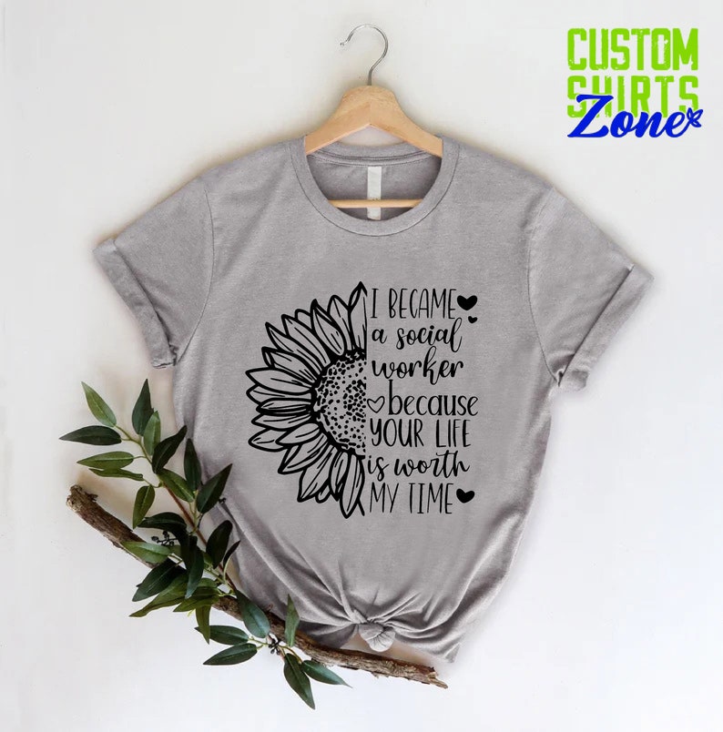 May include: Gray t-shirt with a sunflower graphic and the text "I became a social worker because your life is worth my time".