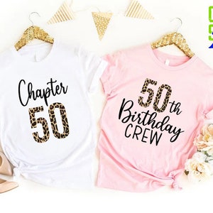 May include: Two t-shirts, one white and one pink, with a leopard print design. The white shirt says "Chapter 50" and the pink shirt says "50th Birthday Crew".