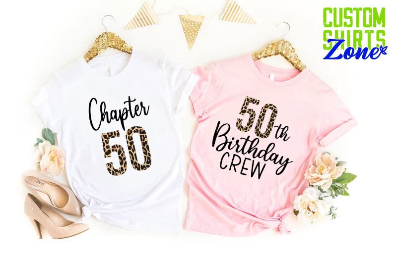 May include: Two t-shirts, one white and one pink, with a leopard print design. The white shirt says "Chapter 50" and the pink shirt says "50th Birthday Crew".