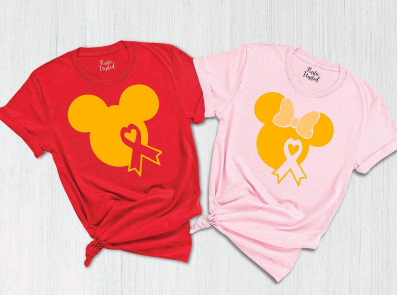 K&ouml;nnte beinhalten: Zwei T-Shirts mit einem gelben Mickey Mouse und Minnie Mouse Design. Das Mickey Mouse Shirt ist rot und das Minnie Mouse Shirt ist rosa. Beide Shirts haben ein gelbes Band mit einem Herzen in der Mitte.