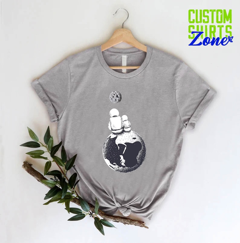 a t - shirt with a picture of a hand holding a soccer ball
