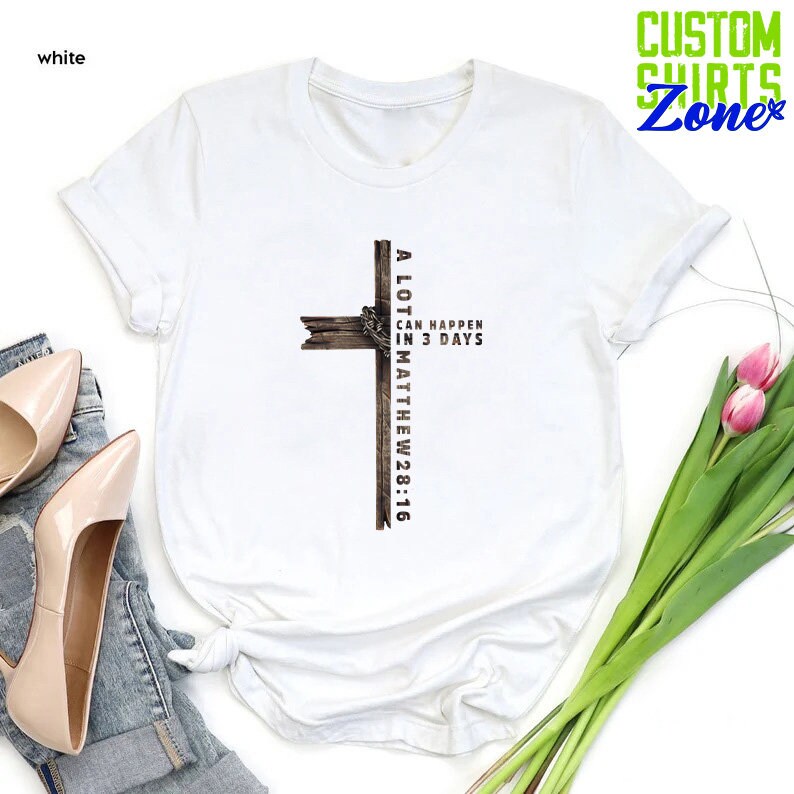 May include: White t-shirt with a brown wooden cross and the text "A LOT CAN HAPPEN IN 3 DAYS MATTHEW 28:16".