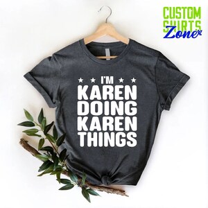 May include: A dark gray t-shirt with white text that reads "I'm Karen Doing Karen Things".