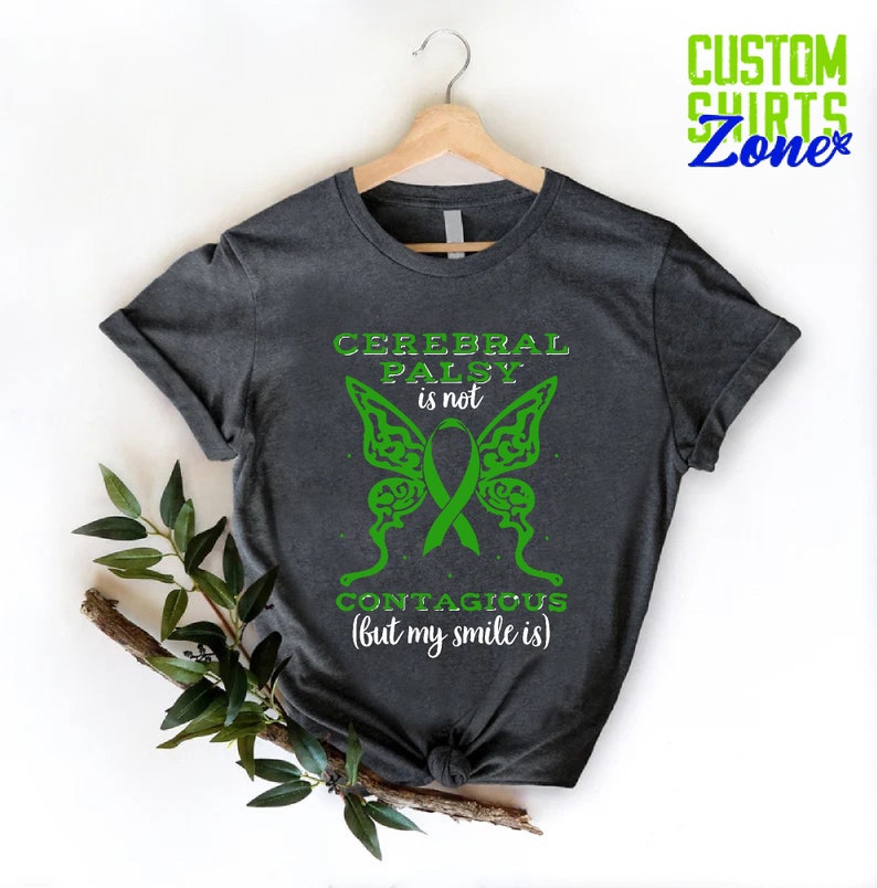 May include: A dark gray t-shirt with a green butterfly design and the text "Cerebral Palsy is not contagious (but my smile is)".
