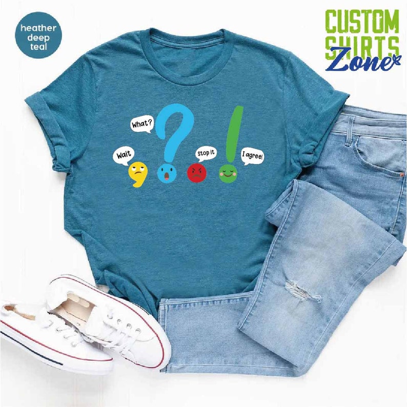 May include: A teal blue t-shirt with a graphic of punctuation marks with faces. The punctuation marks are a comma, question mark, exclamation point, and period. The text on the shirt reads "Wait", "What?", "Stop it", and "I agree!"