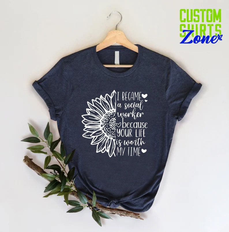 May include: A navy blue t-shirt with a white sunflower graphic and the text "I became a social worker because your life is worth my time".