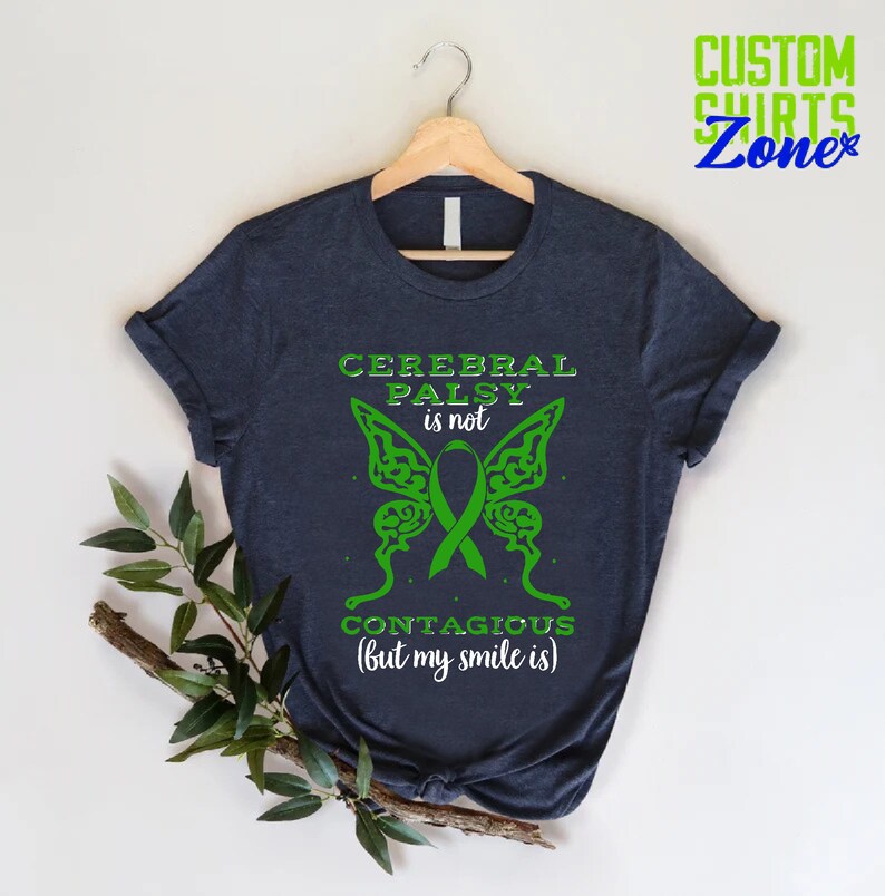 May include: A dark blue t-shirt with a green butterfly design and the text "Cerebral Palsy is not contagious (but my smile is)".