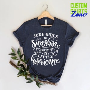 May include: A navy blue t-shirt with white text that reads "June Girls Are Sunshine Mixed With A Little Hurricane".