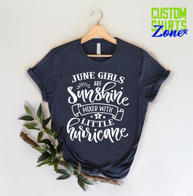 May include: A navy blue t-shirt with white text that reads "June Girls Are Sunshine Mixed With A Little Hurricane".