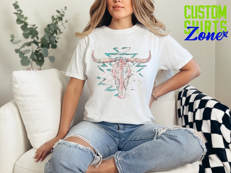 a woman sitting on a couch wearing a t - shirt with a bull's