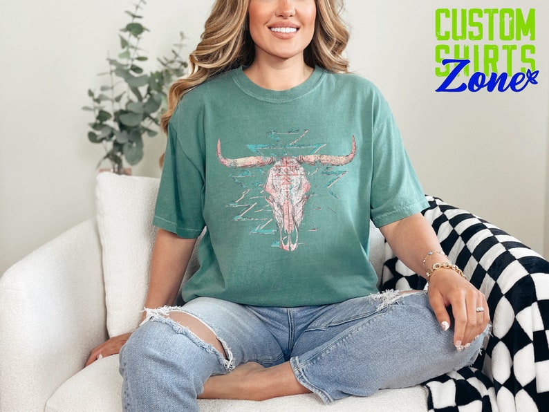 a woman sitting on a couch wearing a green shirt