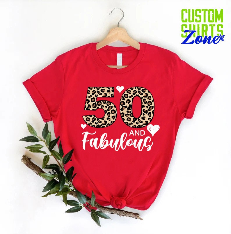 K&ouml;nnte beinhalten: Rotes T-Shirt mit einem Leopardenmuster 50 und dem Text "and Fabulous" in Wei&szlig;.