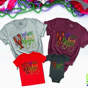 May include: A set of four shirts featuring a crawfish design with the text "I just want to be loved in da bayou". The shirts are in grey, maroon, red, and dark grey.