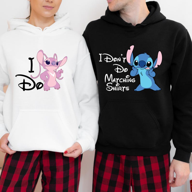May include: A couple wearing matching hoodies with Stitch from Lilo & Stitch. The woman's hoodie is white with pink Stitch and says "I Do". The man's hoodie is black with blue Stitch and says "I Don't Do Matching Shirts".