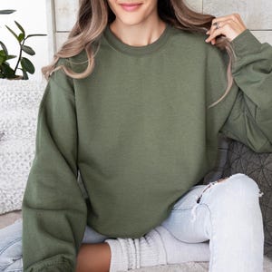 Puede incluir: Una sudadera verde de gran tama&ntilde;o con mangas largas y cuello redondo.