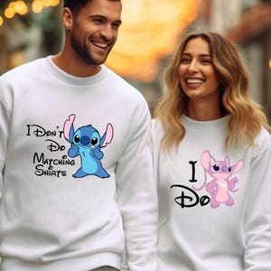 May include: A white sweatshirt with a blue Stitch character and the text "I Don't Do Matching Shirts". A second white sweatshirt with a pink Stitch character and the text "I Do" in a Disney font.