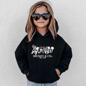 May include: Black hooded sweatshirt with a white graphic of Mickey Mouse and friends. The text "MICKEY & CO. EST. 1928" is printed below the graphic.