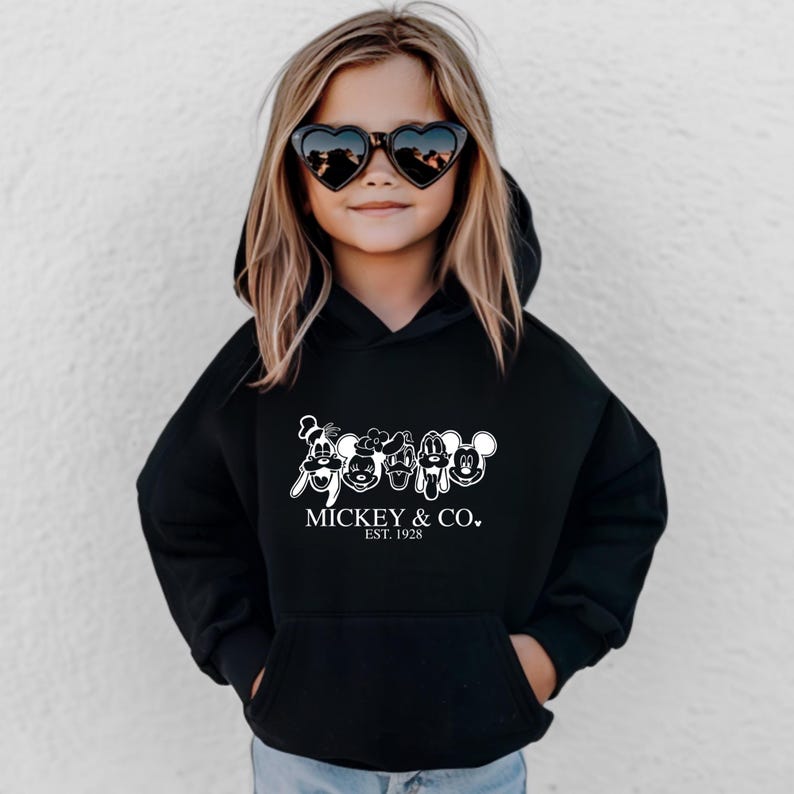May include: Black hooded sweatshirt with a white graphic of Mickey Mouse and friends. The text "MICKEY & CO. EST. 1928" is printed below the graphic.