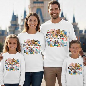 May include: White sweatshirts with a colorful graphic that says "California Adventure". The graphic includes a Ferris wheel, cartoon characters, and other amusement park elements. The sweatshirts are worn by a family of four.
