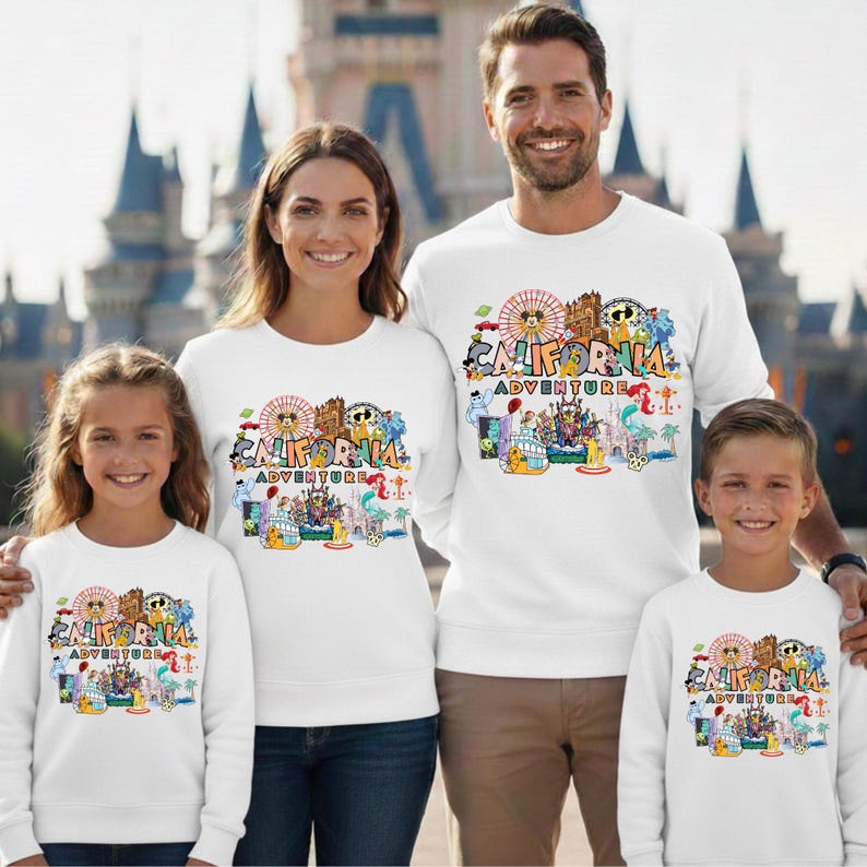 May include: White sweatshirts with a colorful graphic that says "California Adventure". The graphic includes a Ferris wheel, cartoon characters, and other amusement park elements. The sweatshirts are worn by a family of four.