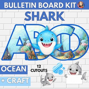 May include: A bulletin board kit featuring the text BULLETIN BOARD KIT SHARK OCEAN + CRAFT 12 CUTOUTS. The design includes large blue-outlined letters A, B, and C filled with an underwater coral reef pattern, a blue shark illustration, and two gray sharks.