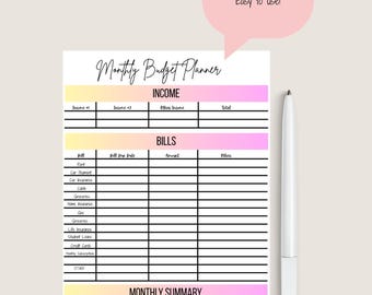 May include: A white monthly budget planner with sections for income, bills, and a monthly summary. The planner has a gradient of yellow to pink colours. A white pen is placed next to the planner. Text on the image says "Monthly Budget Planner" and "Easy to use!"