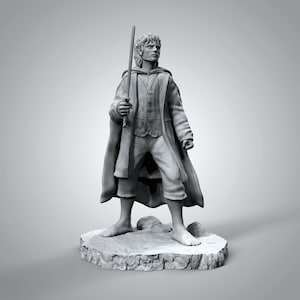 Pode incluir: Uma figura cinzenta de um personagem de O Senhor dos Anéis, segurando uma espada e vestindo uma capa e uma túnica.