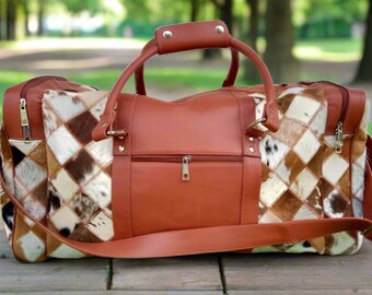 May include: A brown leather travel bag with a patchwork design of brown, white, and black cowhide. The bag has a top handle and a shoulder strap.