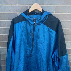 May include: A blue and black windbreaker jacket with a zip fastening and a drawstring hood.