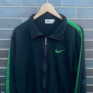 May include: Black zip-up jacket with green stripes down the sleeves and a green Nike logo on the chest. The tag reads "Nike" in white text.
