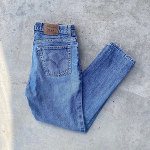 May include: A pair of blue denim jeans with a brown leather patch that says "Levi's" on the back pocket.
