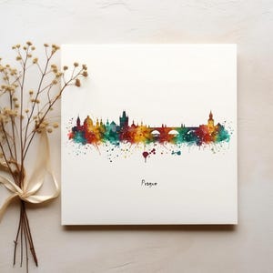 Pode incluir: Uma pintura em aquarela do horizonte de Praga com respingos de tinta coloridos. As pontes e edifícios icônicos da cidade são representados de forma estilizada. A palavra "Praga" está escrita abaixo do horizonte.